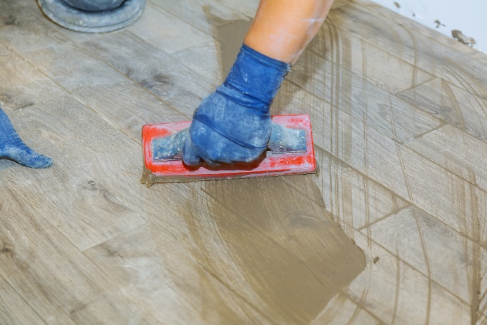 hand re-grouting grey tiles